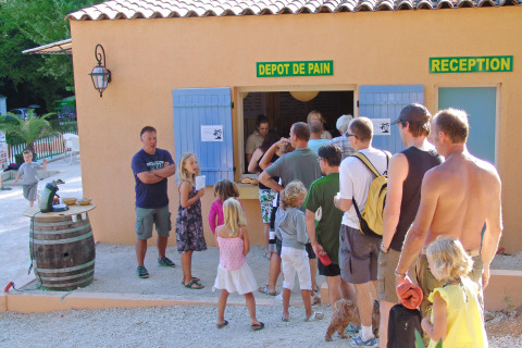 Huéspedes esperan en fila en la panadería y recepción de Slow Village Provence Occitane, Occitanie.