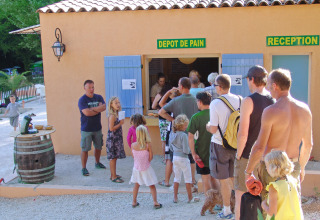 Feriepark-gæster står i kø foran et bageri og reception i Slow Village Provence Occitane, Occitanie.