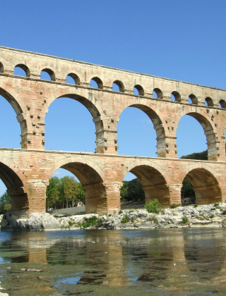 El acueducto romano Pont du Gard cerca de La Roque-sur-Cèze, Occitania, Francia, sobre el río al mediodía.
