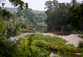 Rustige rivier en groene natuur bij Slow Village Provence Occitane vakantiepark in Occitanie, Frankrijk.