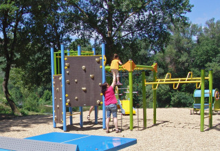 Bambini giocano su un parco giochi con parete da arrampicata al Slow Village Provence Occitane, Occitania, Francia.