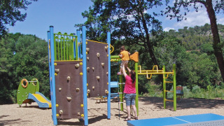 Parque infantil rodeado de naturaleza en Slow Village Provence Occitane, Occitanie, Francia, con niños y adultos.