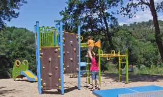 Parque infantil rodeado de naturaleza en Slow Village Provence Occitane, Occitanie, Francia, con niños y adultos.
