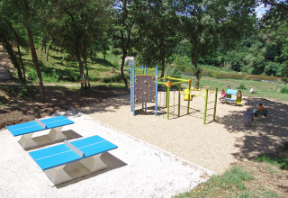 Speelplein met klimrek, pingpongtafels en groene omgeving in Slow Village Provence Occitane, Frankrijk.
