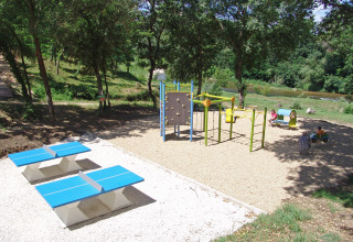 Parco giochi con struttura arrampicata, tavoli da ping pong e verde a Slow Village Provence Occitane, Francia.