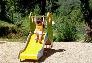 Een kind speelt op een glijbaan in Slow Village Provence Occitane vakantiepark in Occitanië, Frankrijk.