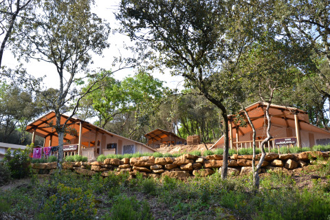 Tentes safari au milieu des arbres au Slow Village Provence Occitane, parc de vacances en Occitanie, France.
