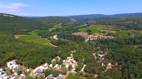 Aerial view of Slow Village Provence Occitane, a holiday park surrounded by forest and fields in Occitanie, France.