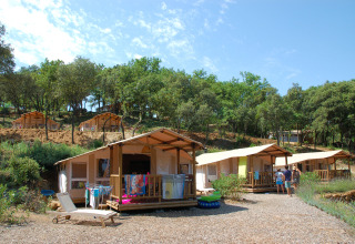 Hutten en tenten tussen de bomen bij Slow Village Provence Occitane, een vakantiepark in Occitanië, Frankrijk.