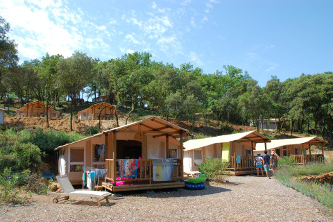Casette e tende tra gli alberi presso Slow Village Provence Occitane, villaggio vacanze in Occitania, Francia.