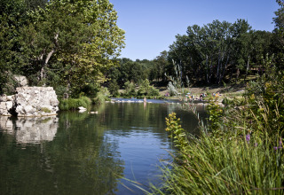 Rivier en grasvelden bij Slow Village Provence Occitane, Occitanië, Frankrijk met ontspannen bezoekers.