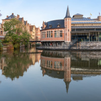 Edificios históricos y aguas tranquilas de un canal reflejan el encanto de Jabbeke, Flandes Occidental, Bélgica.
