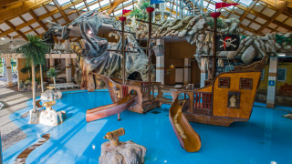 Parque acuático cubierto con barco pirata, toboganes y decoración temática en Camping Terme Catez, Eslovenia.