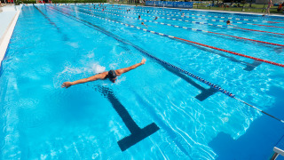 Piscina exterior en Camping Terme Catez, Eslovenia, con nadadores disfrutando bajo el sol de verano.