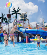 Niños jugando en el parque acuático con toboganes y fuentes en Camping Terme Catez, Eslovenia.