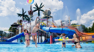Niños jugando en el parque acuático con toboganes y fuentes en Camping Terme Catez, Eslovenia.