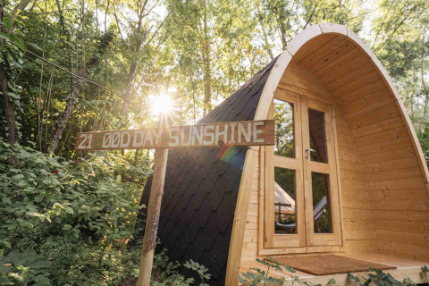 Cabaña de madera en el bosque con letrero 'GOOD DAY SUNSHINE', sol brillante en RØSTIG, Utrecht, Países Bajos.
