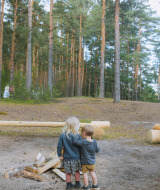 Dos niños abrazados cerca de una fogata en un claro del bosque en Virton, Luxemburgo belga, Bélgica.