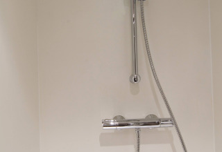Douche met verstelbare douchekop en chromen mengkraan in het RoyalLodge safaritent te Slow Village Provence Occitane.