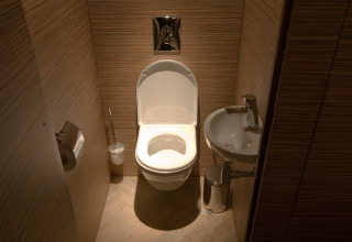 Moderne wc en kleine lavabo in privébadkamer van RoyalLodge safaritent, Slow Village Provence Occitane, Frankrijk.
