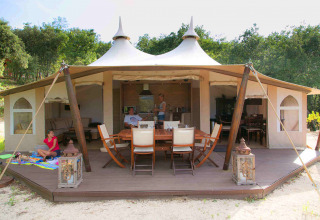 Tienda safari RoyalLodge en Slow Village Provence Occitane, Francia, con terraza de madera y familia relajándose.