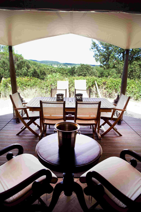 Terraza al aire libre en la tienda safari RoyalLodge en Slow Village Provence Occitane, Francia, con sillas y vistas.
