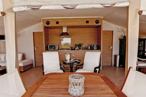 Binnenkant van safaritent RoyalLodge met keuken en zitgedeelte bij Slow Village Provence Occitane Frankrijk.