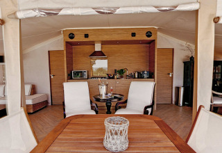 Vista interior de la tienda safari RoyalLodge, con cocina y comedor en Slow Village Provence Occitane, Francia.
