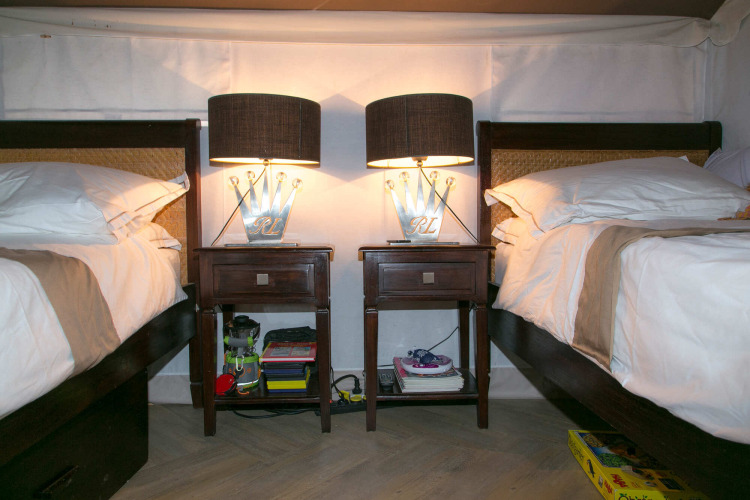 Interior de la tienda safari RoyalLodge con dos camas, mesitas de noche y lámparas en Slow Village Provence Occitane.
