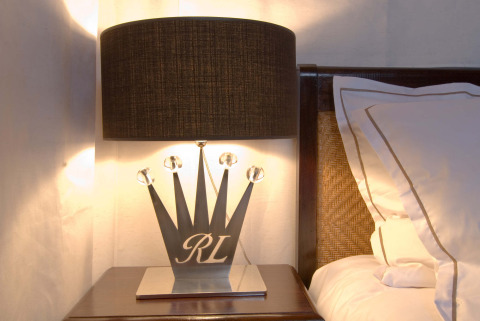 Moderne nachtlamp met zwarte lampenkap en kroonvormige voet in RoyalLodge safaritent, Provence.