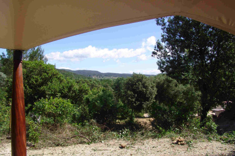Zicht vanuit de RoyalLodge safaritent in Slow Village Provence Occitane, Frankrijk, op groene natuur.