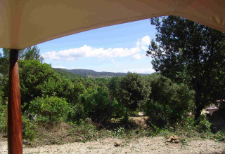Zicht vanuit de RoyalLodge safaritent in Slow Village Provence Occitane, Frankrijk, op groene natuur.