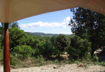 Uitzicht vanuit de RoyalLodge safaritent bij Slow Village Provence Occitane, Frankrijk met groene bossen.
