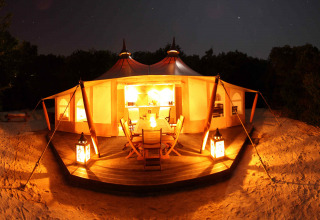 Tienda de safari iluminada RoyalLodge en Slow Village Provence Occitane, Francia, fotografiada de noche.