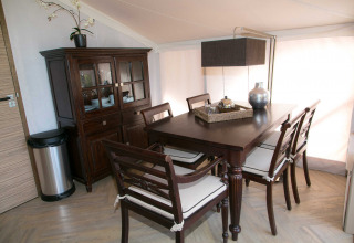 Stijlvolle eethoek in de safaritent RoyalLodge bij Slow Village Provence Occitane, Frankrijk, met houten meubelen.