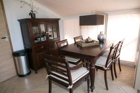 Comedor elegante en la tienda safari RoyalLodge en Slow Village Provence Occitane, Francia, con muebles de madera.