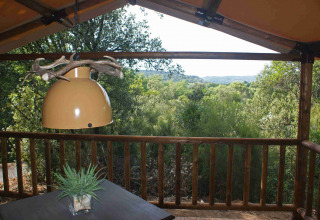 Udsigt fra SunLodge Safari teltet på Slow Village Provence Occitane i Frankrig, med træterrasse og lamper.