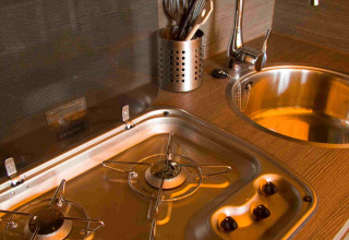 Rincón de cocina en tienda SunLodge Safari en Slow Village Provence Occitane con estufa de gas y fregadero.