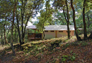 SunLodge Safari-telt blandt træer hos Slow Village Provence Occitane, Frankrig, set i naturlig skovomgivelse.