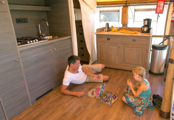 Padre e figlia giocano sul pavimento della cucina di una lussuosa tenda safari in Provenza, Francia.