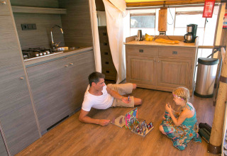 Padre e hija juegan un juego de mesa en el suelo de una lujosa tienda safari en Slow Village Provence Occitane.