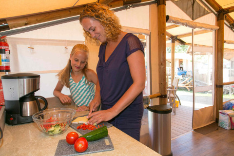 Mor og datter laver mad i et safari telt på SunLodge Safari, Slow Village Provence Occitane i Frankrig.
