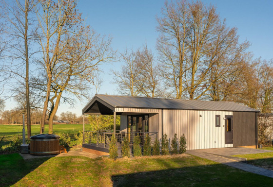 Lodge moderno con terraza, sauna y jacuzzi en Holiday Resort 't Schuttenbelt, Países Bajos, rodeado de naturaleza.