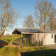 Moderne lodge med terrasse, sauna og spabad på Holiday Resort 't Schuttenbelt i Holland, omgivet af natur.