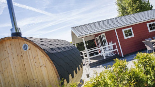 Veluwe lounge con sauna en Holiday park De Boshoek, Países Bajos, con cabina roja y sauna de madera.