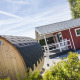 Veluwe lounge og sauna ved Holiday park De Boshoek, med rød hytte og træsauna i solskin.
