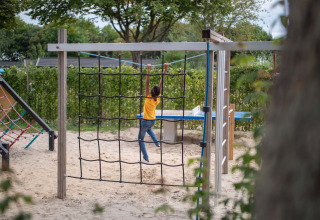 Ein Kind spielt auf einem Spielplatz im Sand im Recreatiepark het Esmeer in Gelderland, Niederlande.