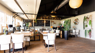 Luminoso y moderno interior de bistró en Recreatiepark het Esmeer, parque vacacional en Gelderland, Países Bajos.