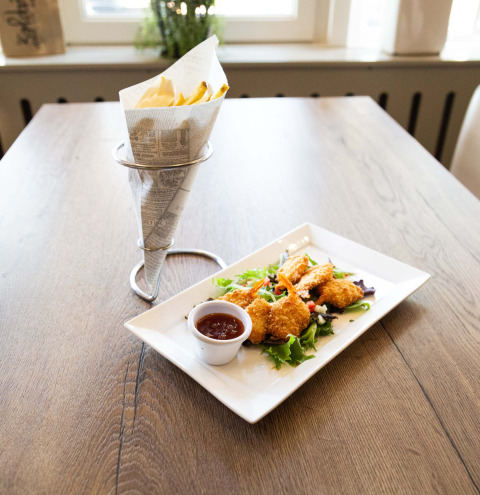 Sprøde rejer med dip og pommes frites serveret på et træbord på Recreatiepark het Esmeer i Gelderland, Holland.