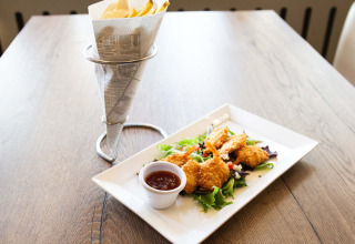 Sprøde rejer med dip og pommes frites serveret på et træbord på Recreatiepark het Esmeer i Gelderland, Holland.